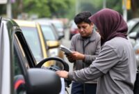 Kompetisi mobil listrik antar universitas di sirkuit jalanan, mahasiswa bersemangat memperbaiki dan menyetel mobil mereka.