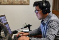 Seorang pria sedang mengedit audio di laptop dengan Audacity Portable terbuka, menunjukkan kemudahan penggunaan di mana saja.