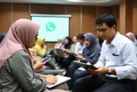 Sekelompok pelaku UMKM (beragam usia dan gender) sedang mengikuti pelatihan atau workshop tentang penggunaan WhatsApp Business, dengan seorang instruktur menjelaskan di depan proyektor. Mereka tampak antusias mencatat di buku dan laptop.